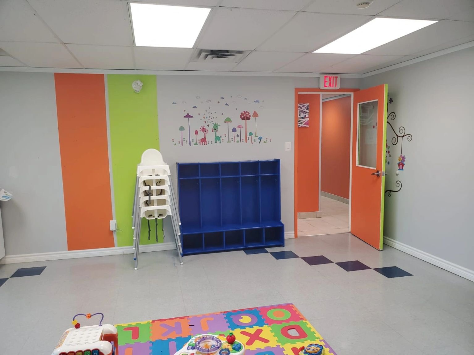 Kanata activity room with a bright alphabet mat and child-height storage.